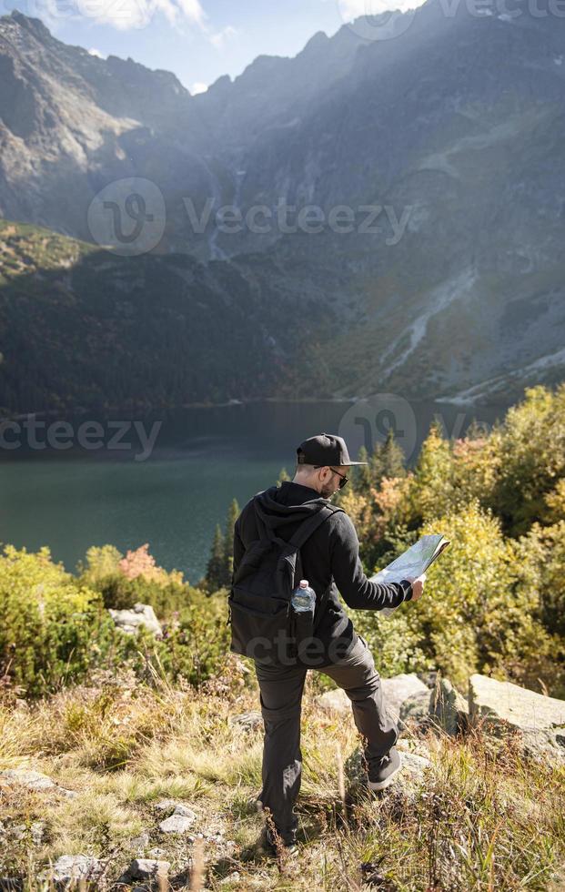 Young man traveler with map and backpack photo