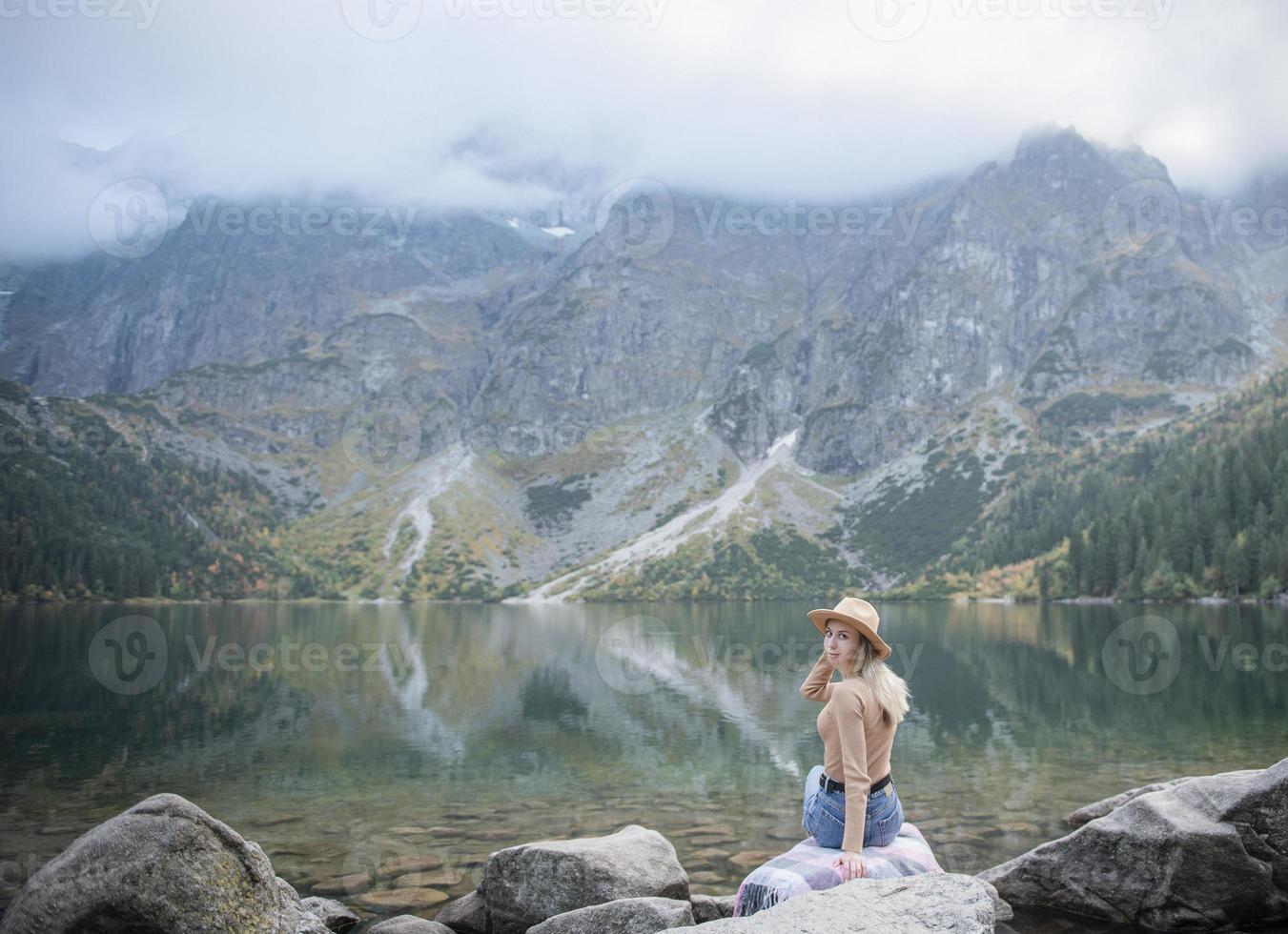 Young woman on a hiking trip sitting on a rock photo