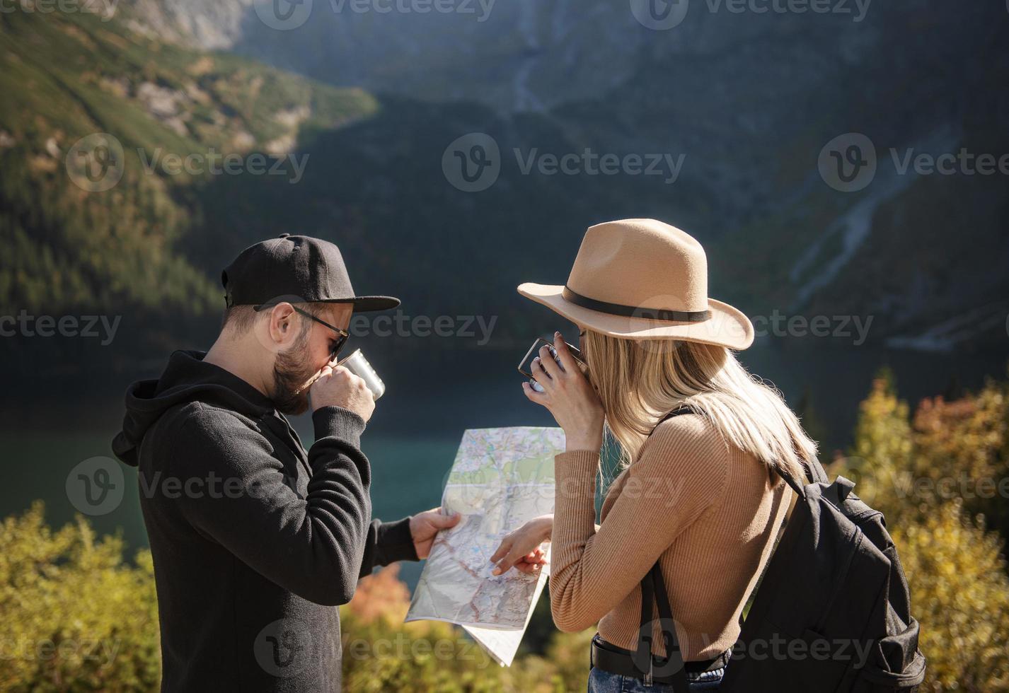 Young tourist couple, man and woman, on hiking path in mountains photo