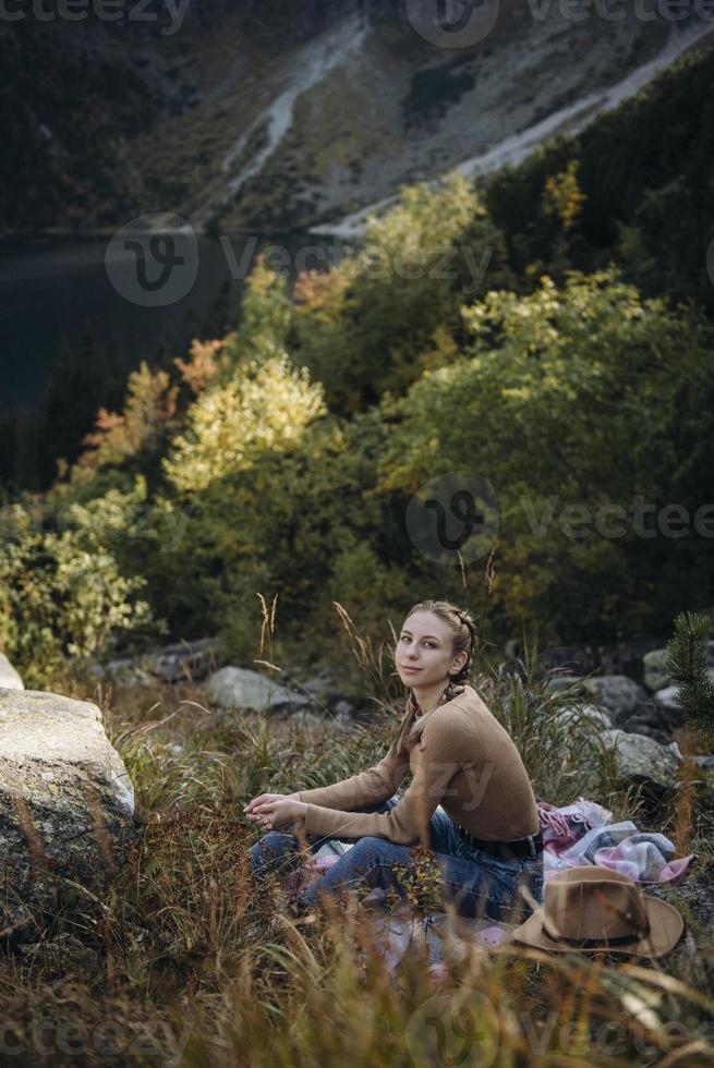 Young woman on a hiking trip sitting on a rock photo