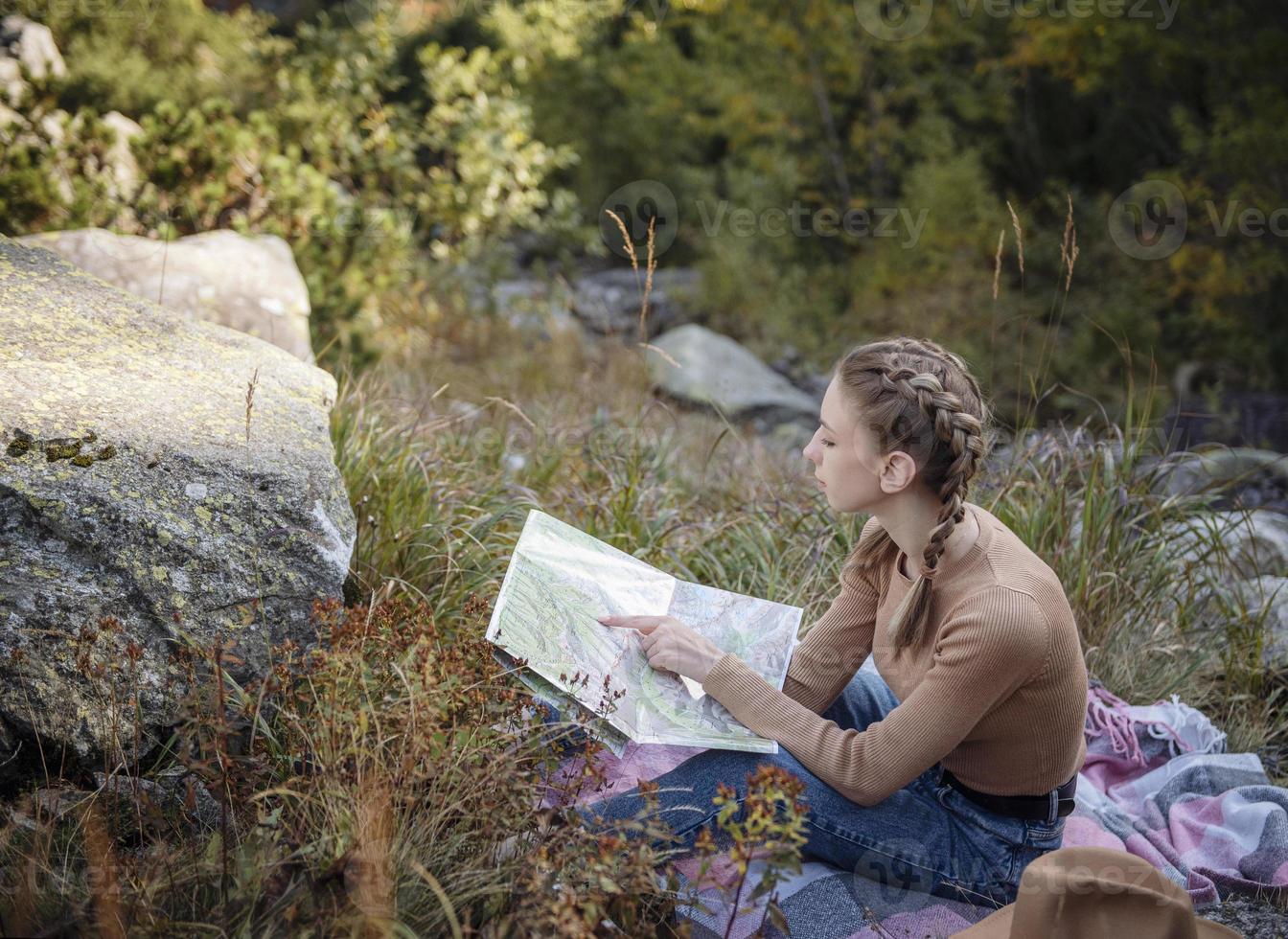 Young woman on a hiking trip sitting on a rock photo