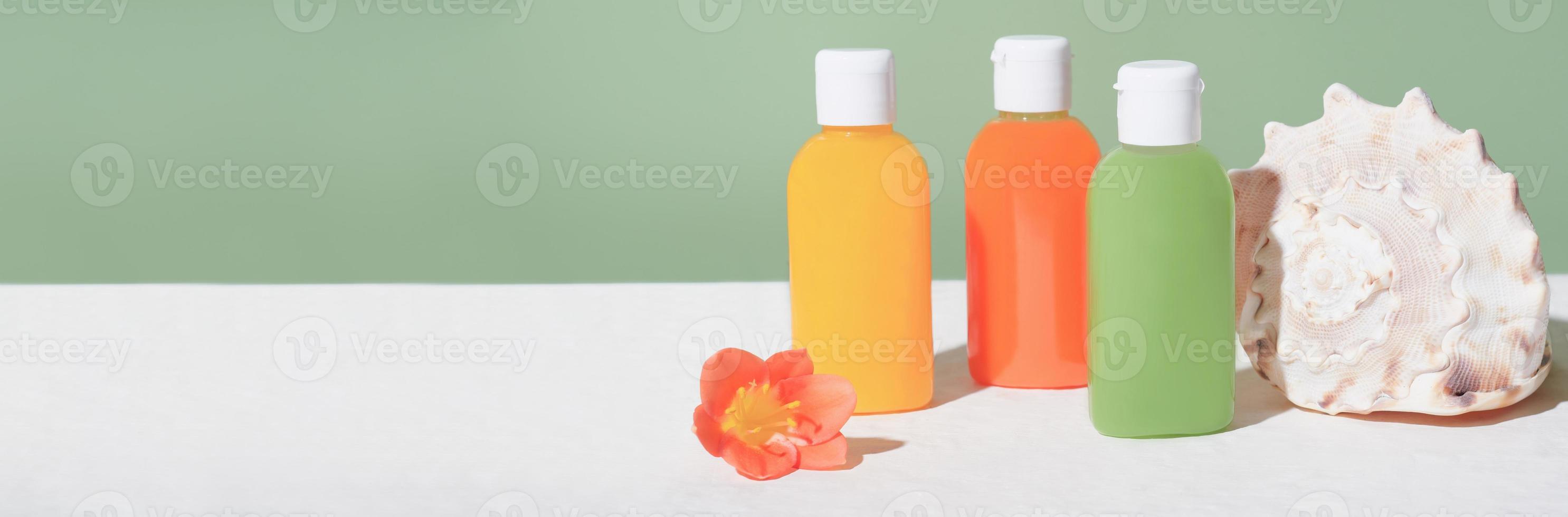 bright travel pack of hygiene product, mini package, travel toiletries, small plastic bottles for vacation. flower and seashell. summer vacation concept, banner photo