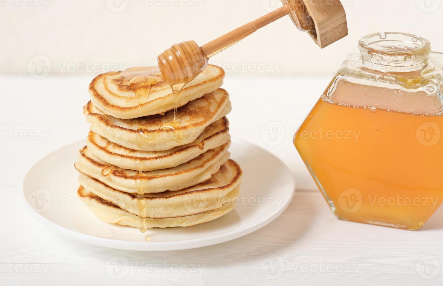 stack of fluffy american pancakes with honey topping. family breakfast or branch recipe. homemade pancakes in a pile. photo