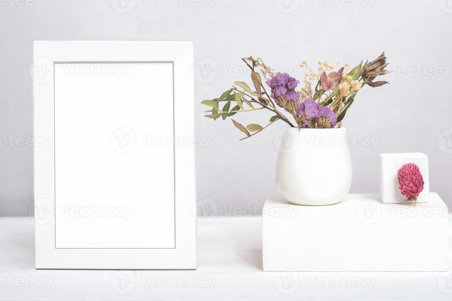 white frame with copy space and dry flowers ina vase on geometric podium or pedestal. template for text or inscription. mock up for sale advertisment or inspirational card photo