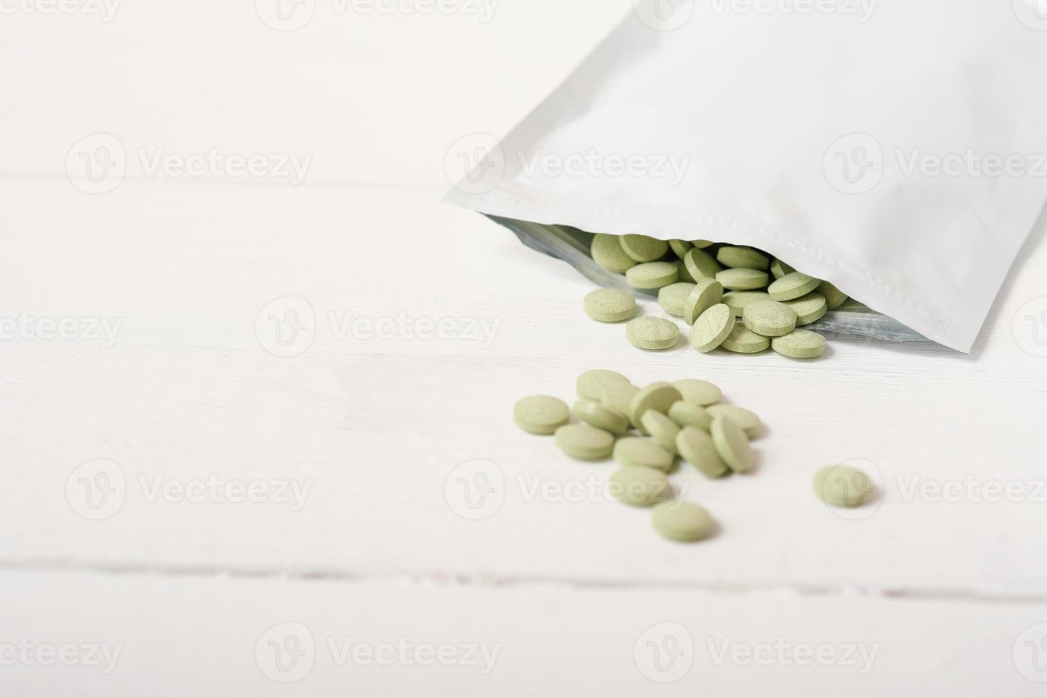 barley grass pills on a table in a zip package. Spirulina and chlorella tablets for detox and metabolism supplement. raw vegan superfood, photo