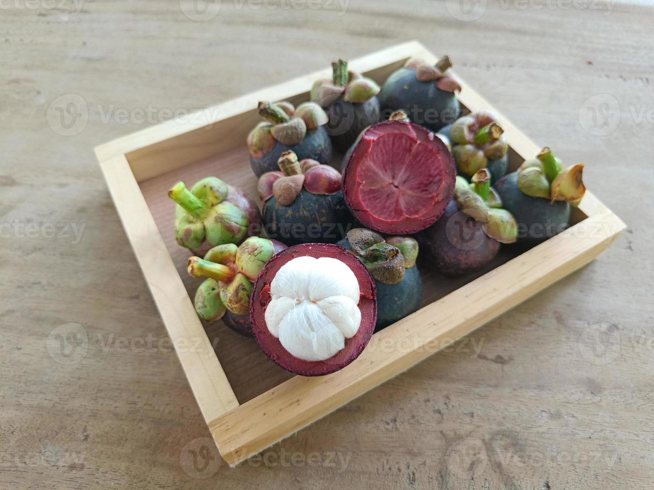Mangosteen on brown tray, fruit from Asia photo