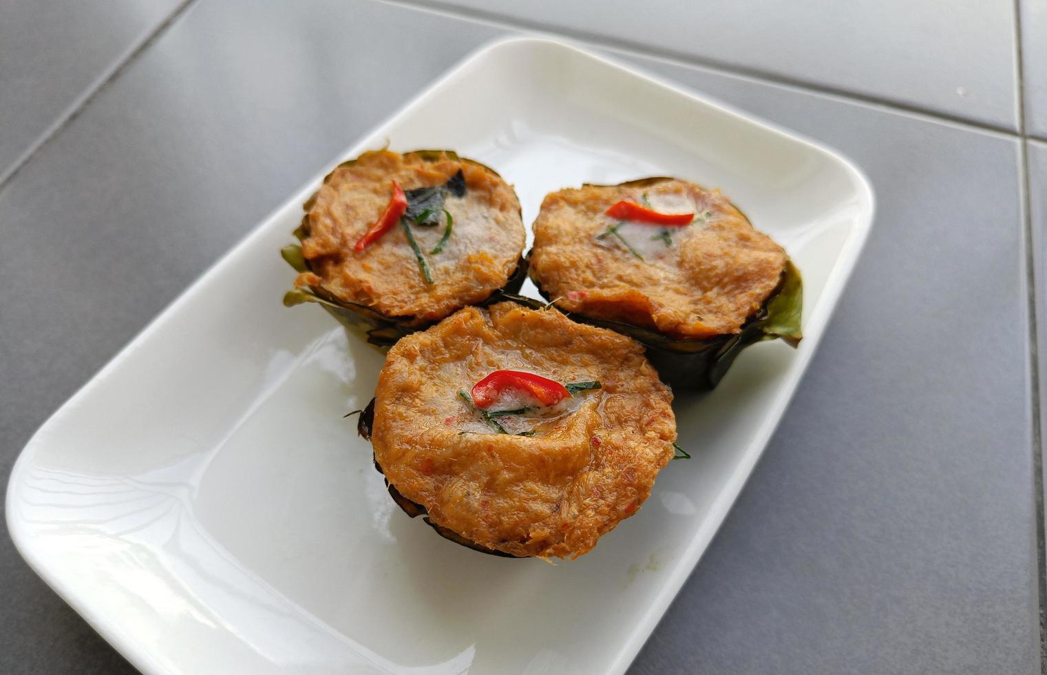 Thai steamed fish with curry paste Ho mok on white plate photo