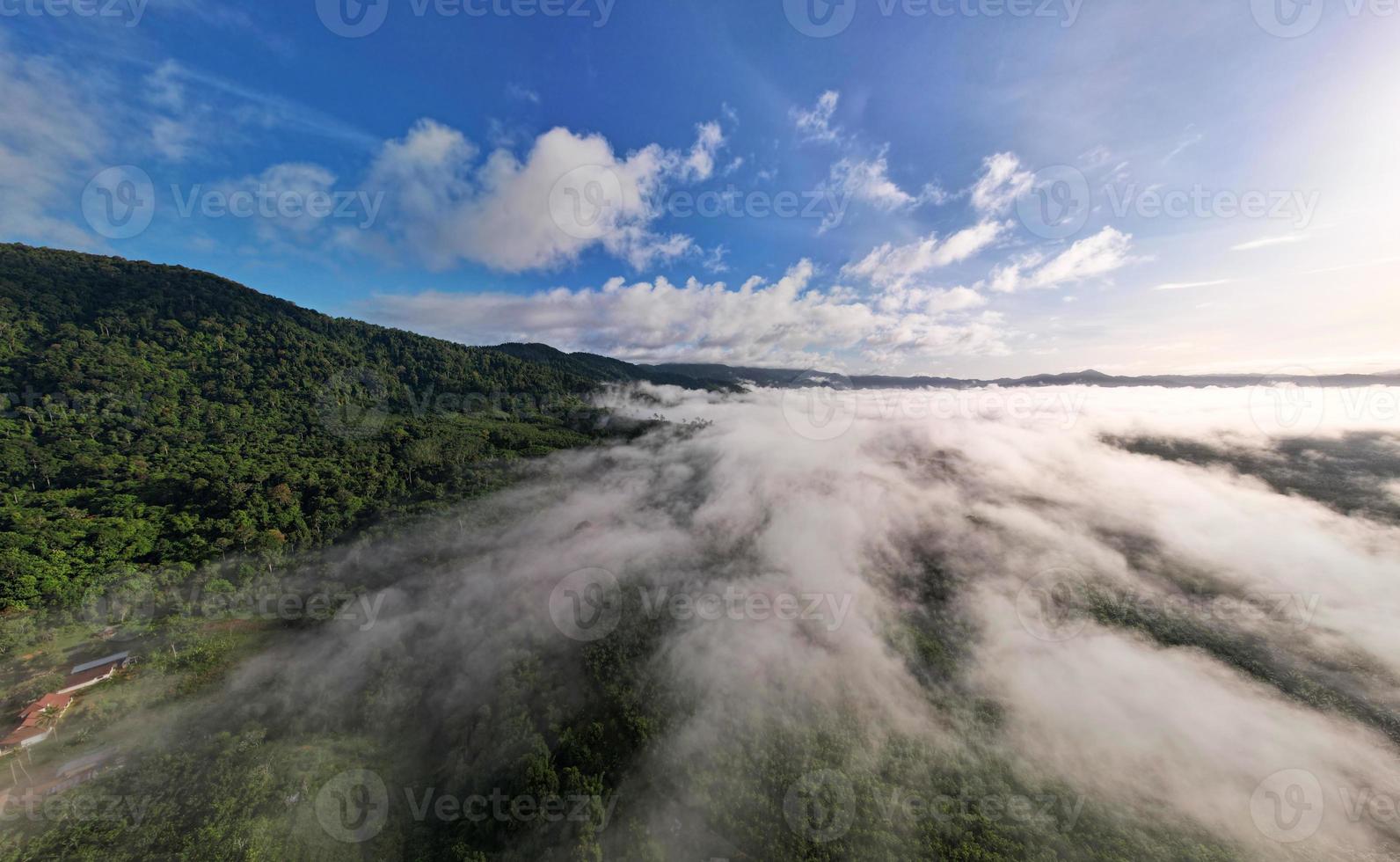 Aerial view Panorama of flowing fog waves on mountain tropical rainforest,Bird eye view image over the clouds Amazing nature background with clouds and mountain peaks in Thailand photo