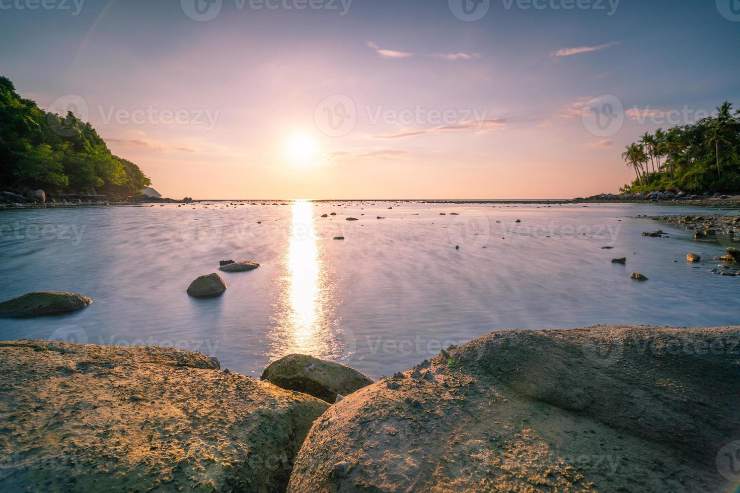 Long exposure image of Dramatic sky seascape with rock in sunset or sunrise sky scenery background Amazing light nature landscape and stones in the foreground photo