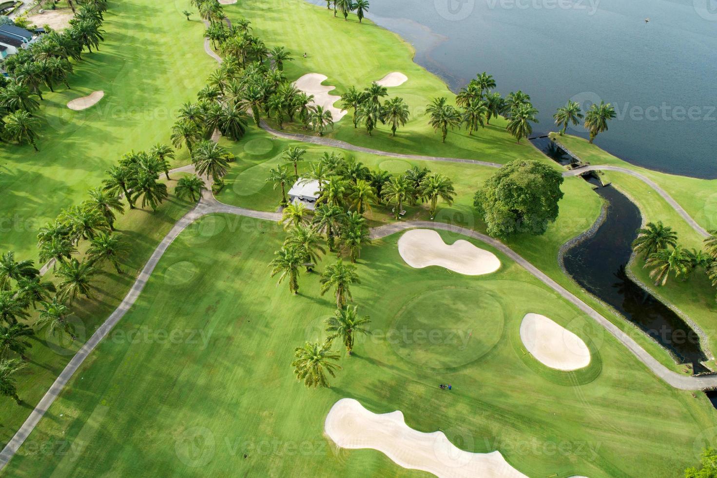 Aerial view of the green golf course in Thailand Beautiful green grass and trees on a golf field with fairway and putting green in summer season photo