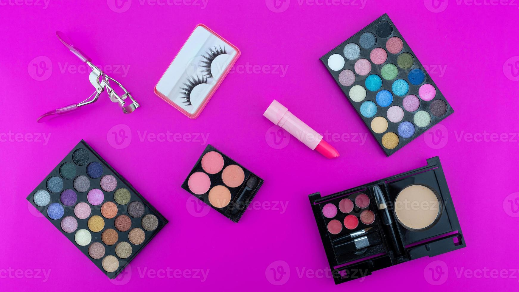 hermosa paleta de sombras de ojos multicolor y varios accesorios cosméticos para maquillaje sobre fondo rosa productos de belleza maquillaje cosmético sombra de ojos de verano foto