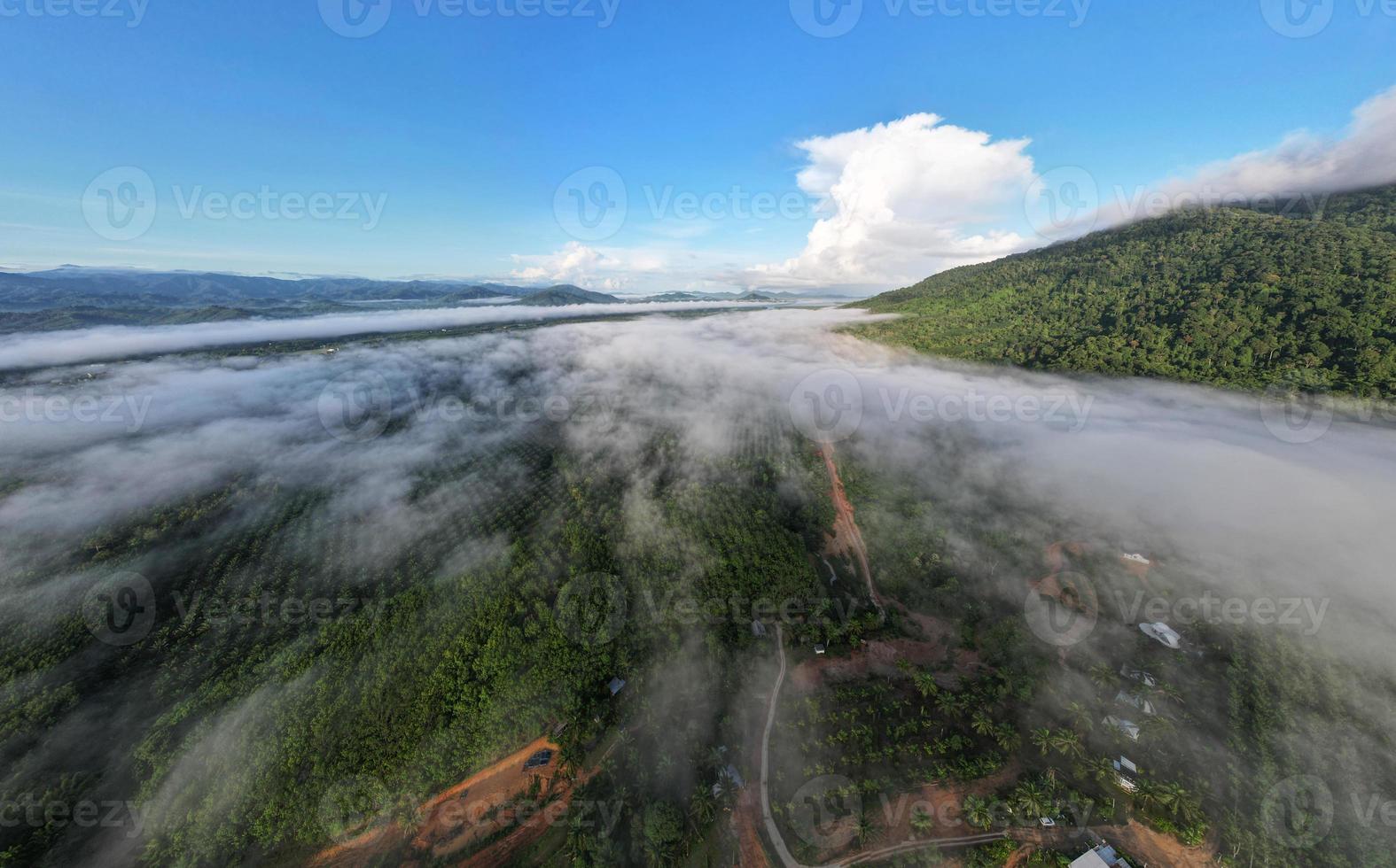 Aerial view Panorama of flowing fog waves on mountain tropical rainforest,Bird eye view image over the clouds Amazing nature background with clouds and mountain peaks in Thailand photo