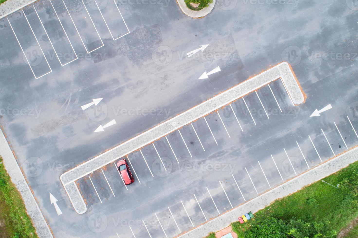 Aerial view top down of red SUV car parked at concrete car parking lot with white line of traffic sign on the street. Above view of car in a row at parking space Outside car parking area photo