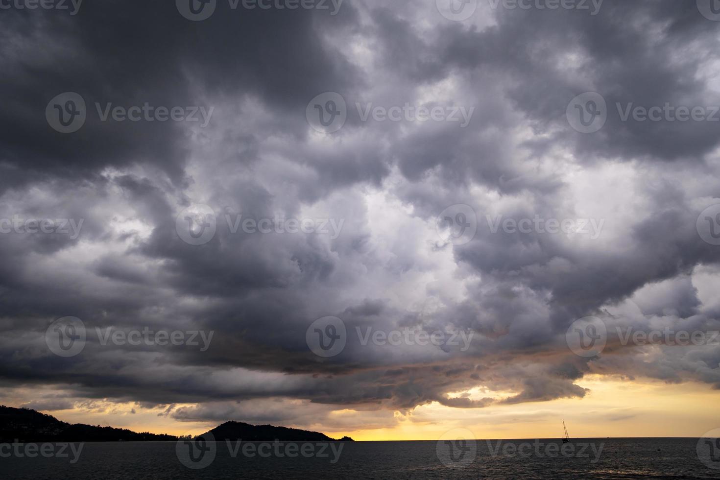 Dark raining clouds over sea in bad weather day photo