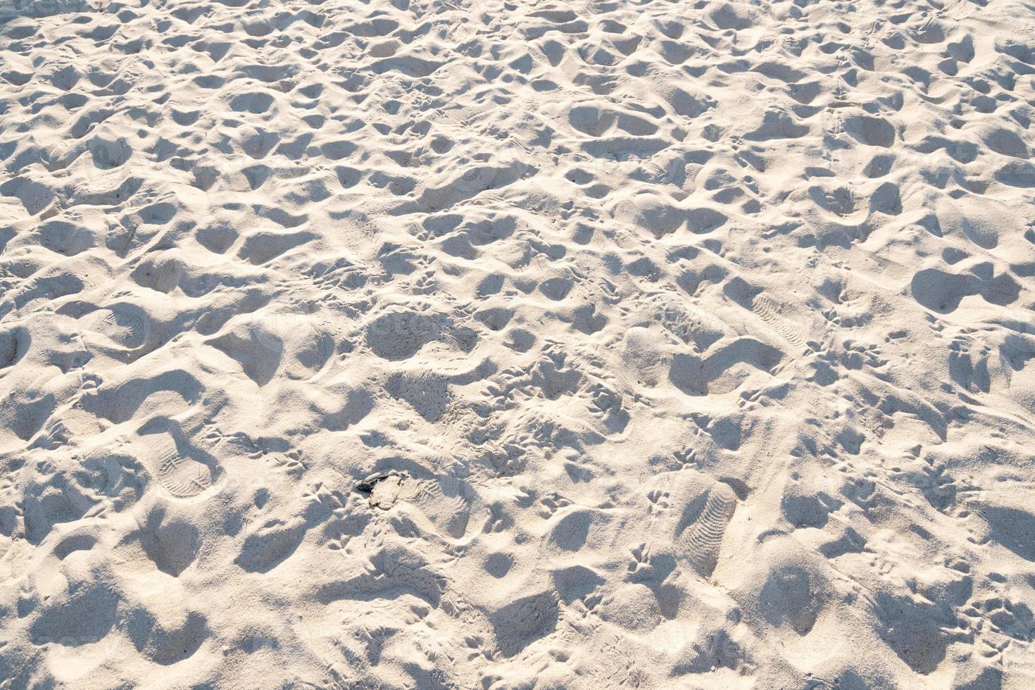 detalle de arena de textura en fondo de verano de isla tropical y diseño de viajes detalle de alta calidad de textura de arena curva.huellas en la playa de arena foto