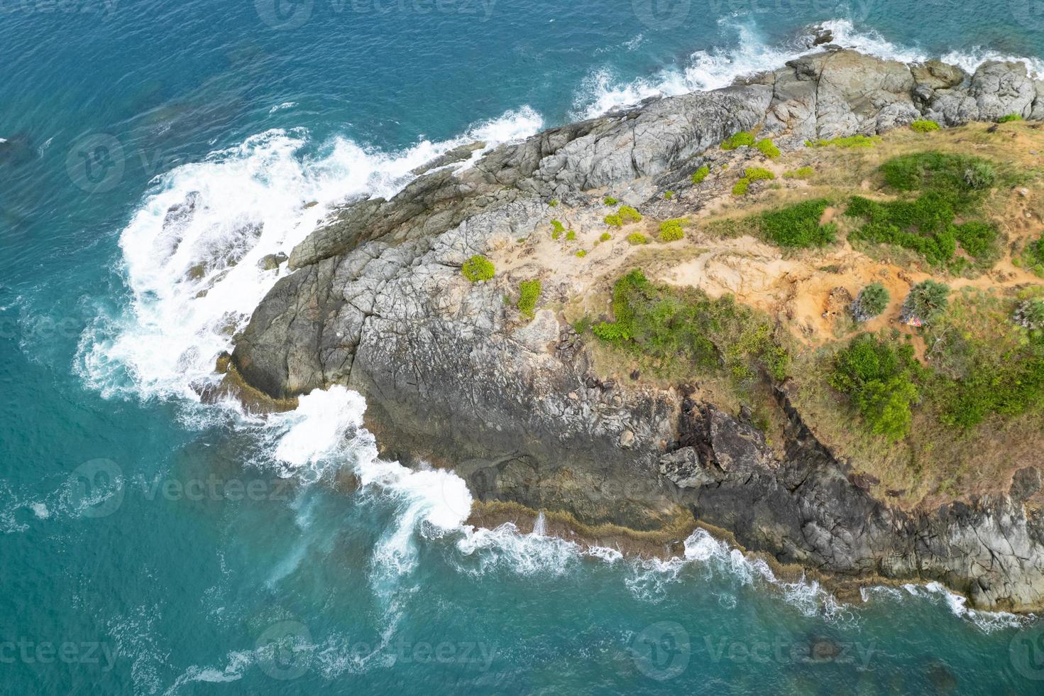 Aerial view Top down seashore big wave crashing on rock cliff Beautiful sea surface in sunny day summer background Amazing seascape top view seacoast at Phuket Thailand photo