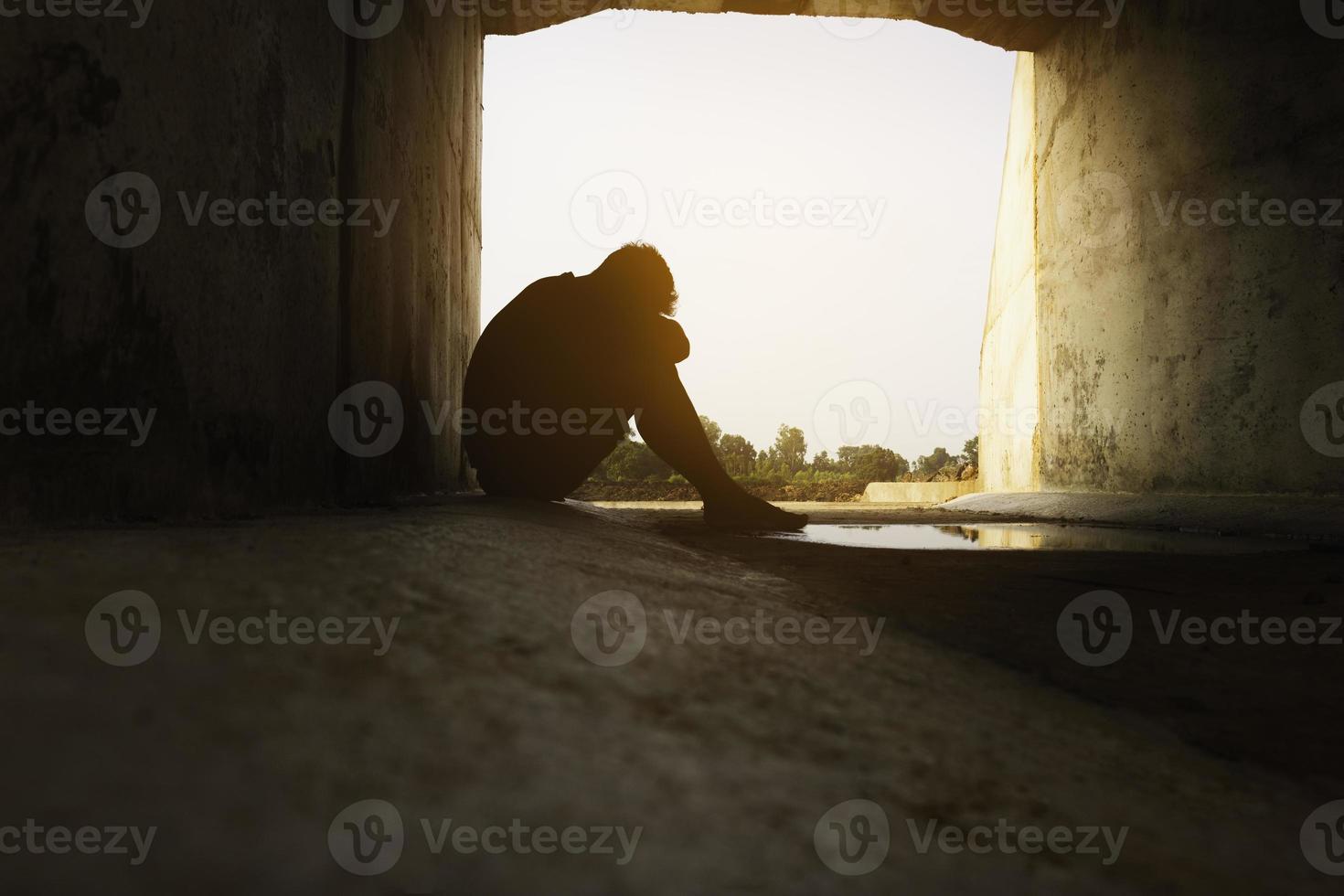 asia tú hombre sentado solo. él sentado debajo de un gran túnel. hombre muy triste y deprimido. triste, solo, suicidio. desesperación. enfermedad.foto concepto de salud y decepción. foto