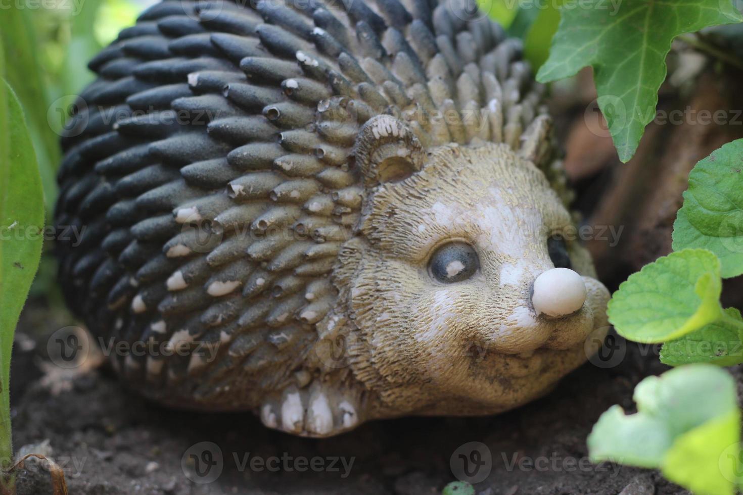 portrait of an animal hedgehog in the garden in flowers, decoration sculpture for the garden photo