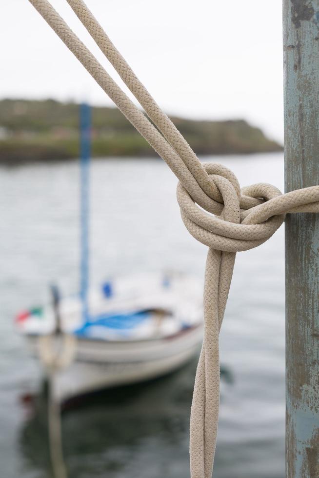 Marine knots on boats with ropes worn by water and sunlight photo