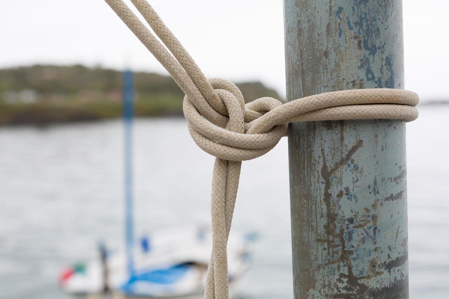 Marine knots on boats with ropes worn by water and sunlight photo