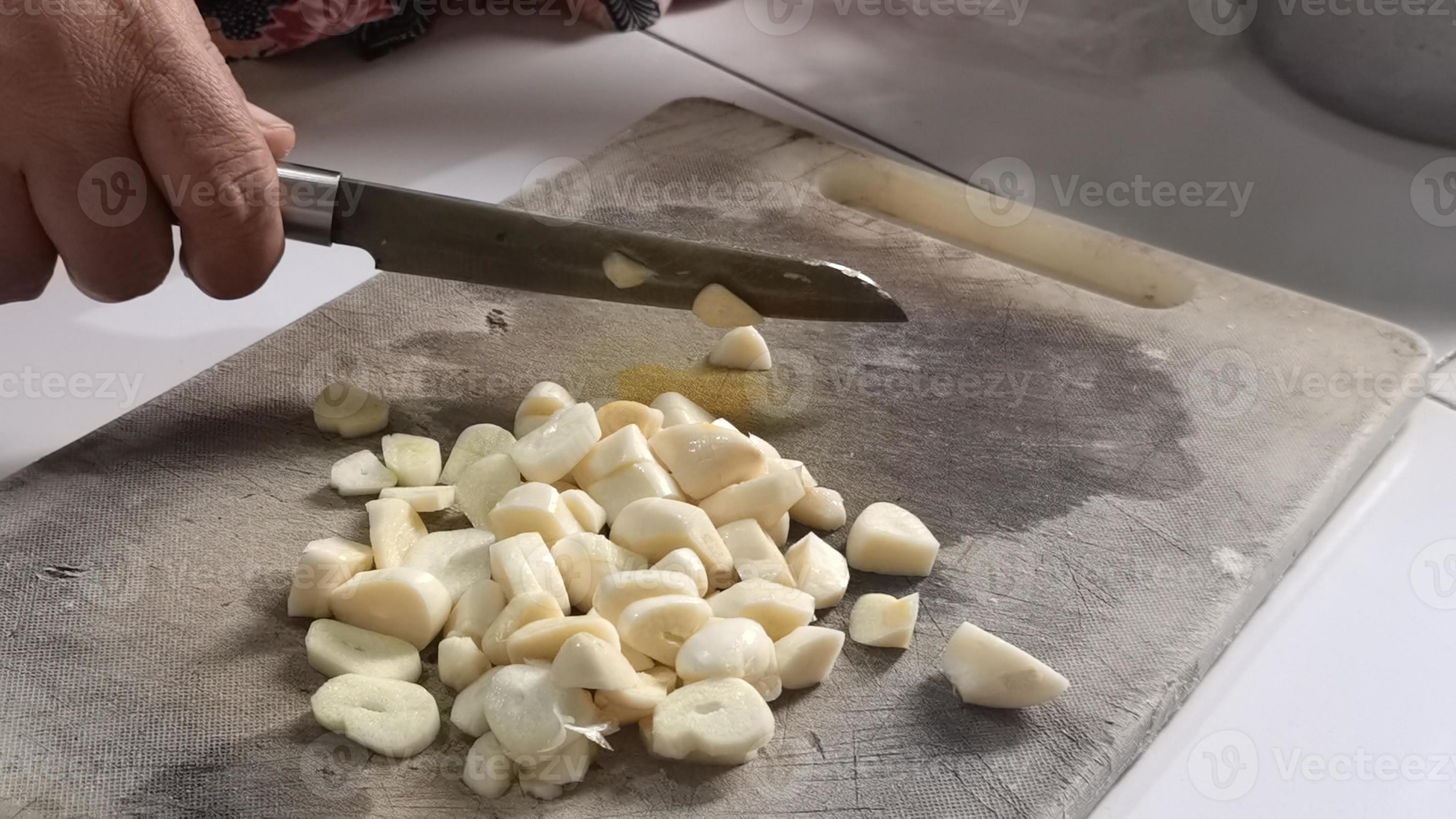 https://static.vecteezy.com/system/resources/previews/008/114/640/large_2x/the-cook-cutting-and-dice-garlic-on-a-cutting-board-photo.jpg