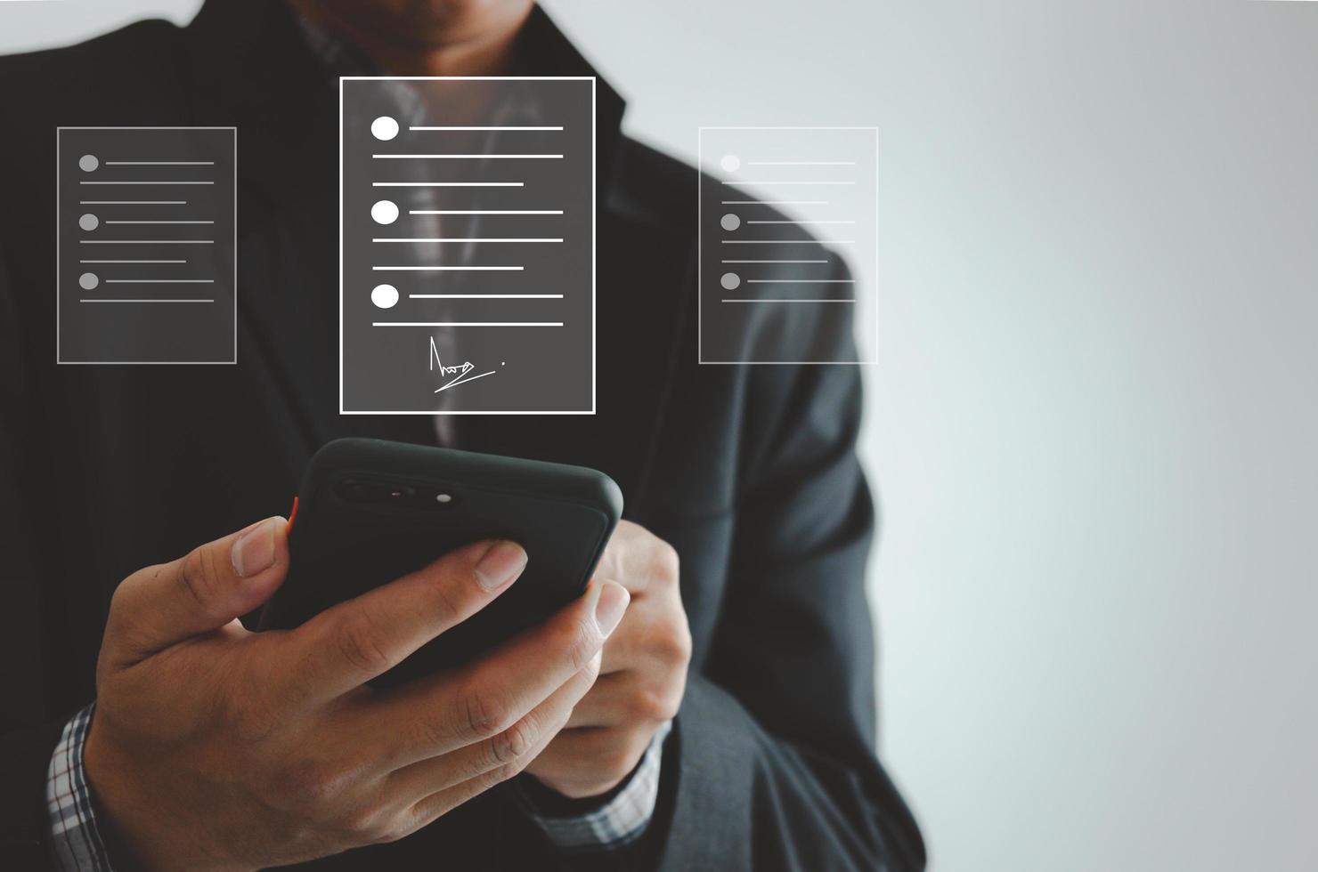 hombre de negocios con documentos de firma digital de negocios de teléfonos inteligentes en pantalla virtual. foto