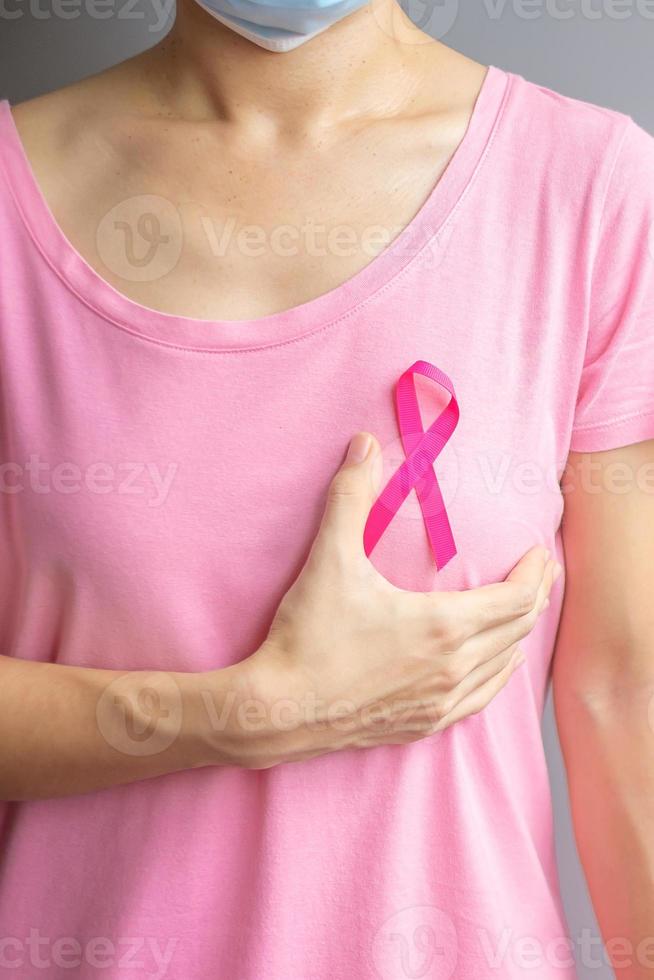 October Breast Cancer Awareness month, elderly Woman in pink T- shirt with hand holding Pink Ribbon for supporting people living and illness. International Women, Mother and World cancer day concept photo