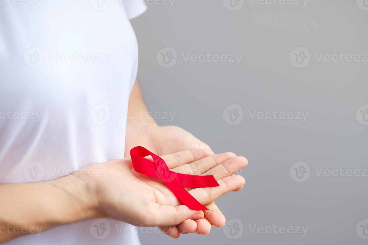 Hand holding Red Ribbon for December World Aids Day , multiple myeloma Cancer Awareness month and National Red ribbon week. Healthcare and world cancer day concept photo