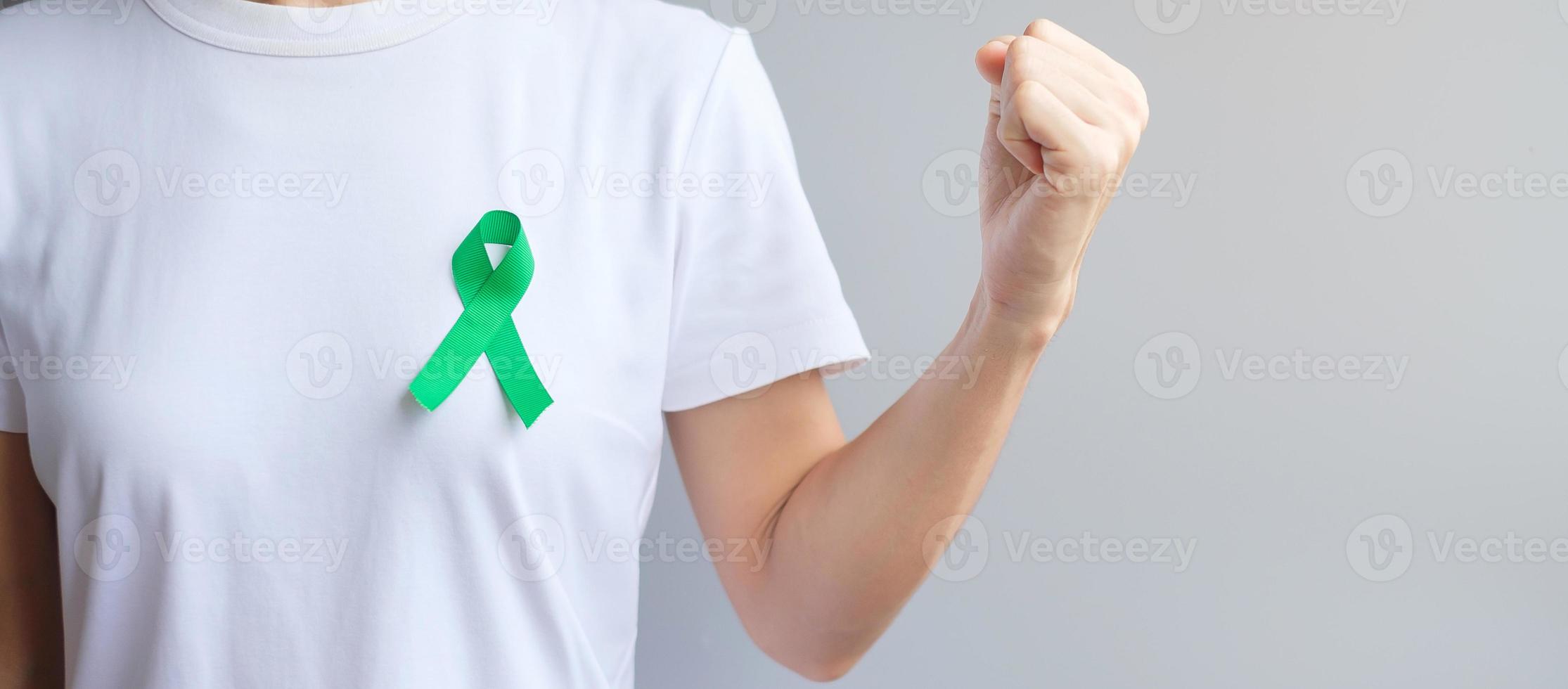 cinta verde para el mes de concientización sobre el hígado, las vesículas biliares, las vías biliares, el cuello uterino, el cáncer de riñón y el linfoma. concepto de salud y día mundial del cáncer foto
