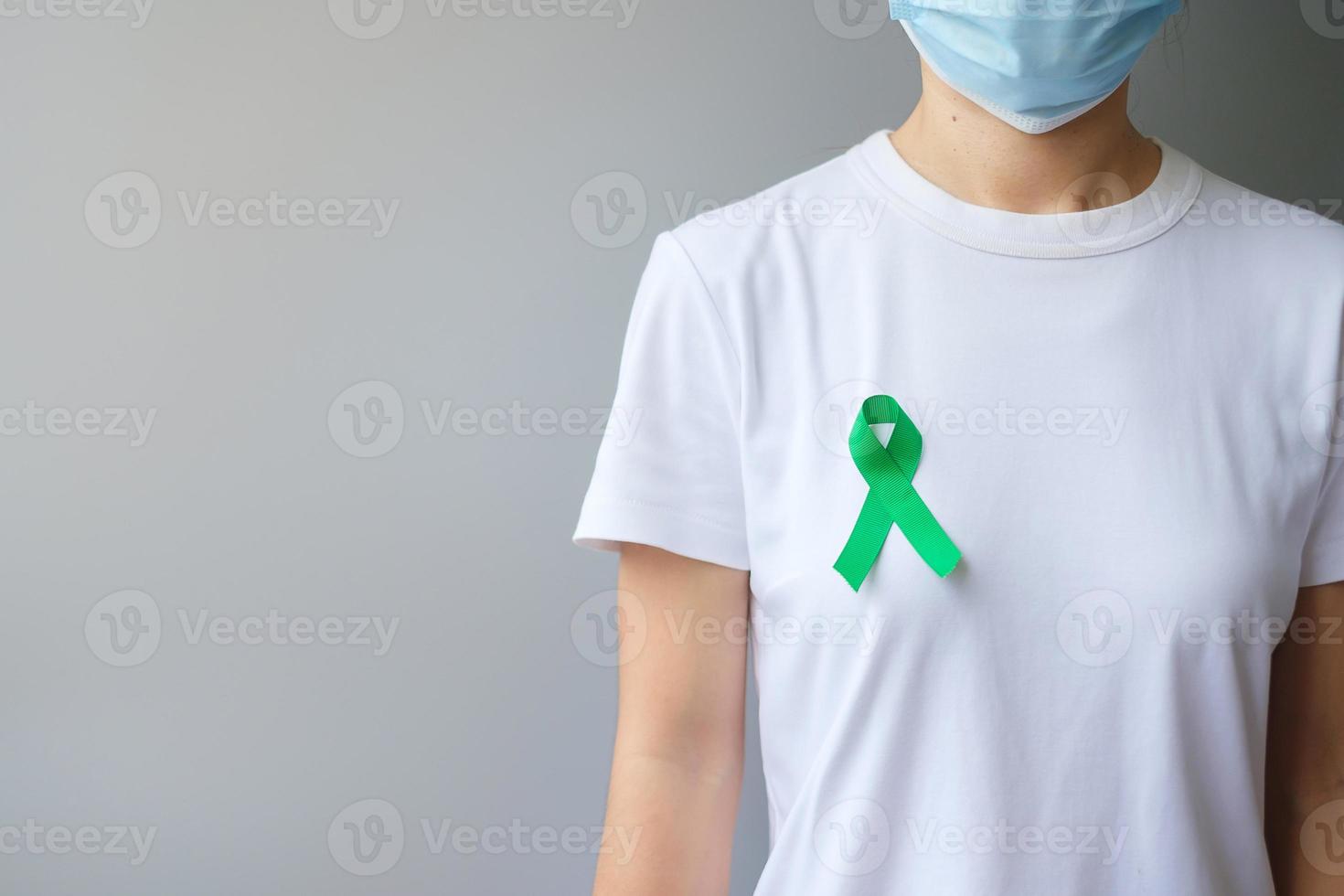 cinta verde para el mes de concientización sobre el hígado, las vesículas biliares, las vías biliares, el cuello uterino, el cáncer de riñón y el linfoma. concepto de salud y día mundial del cáncer foto