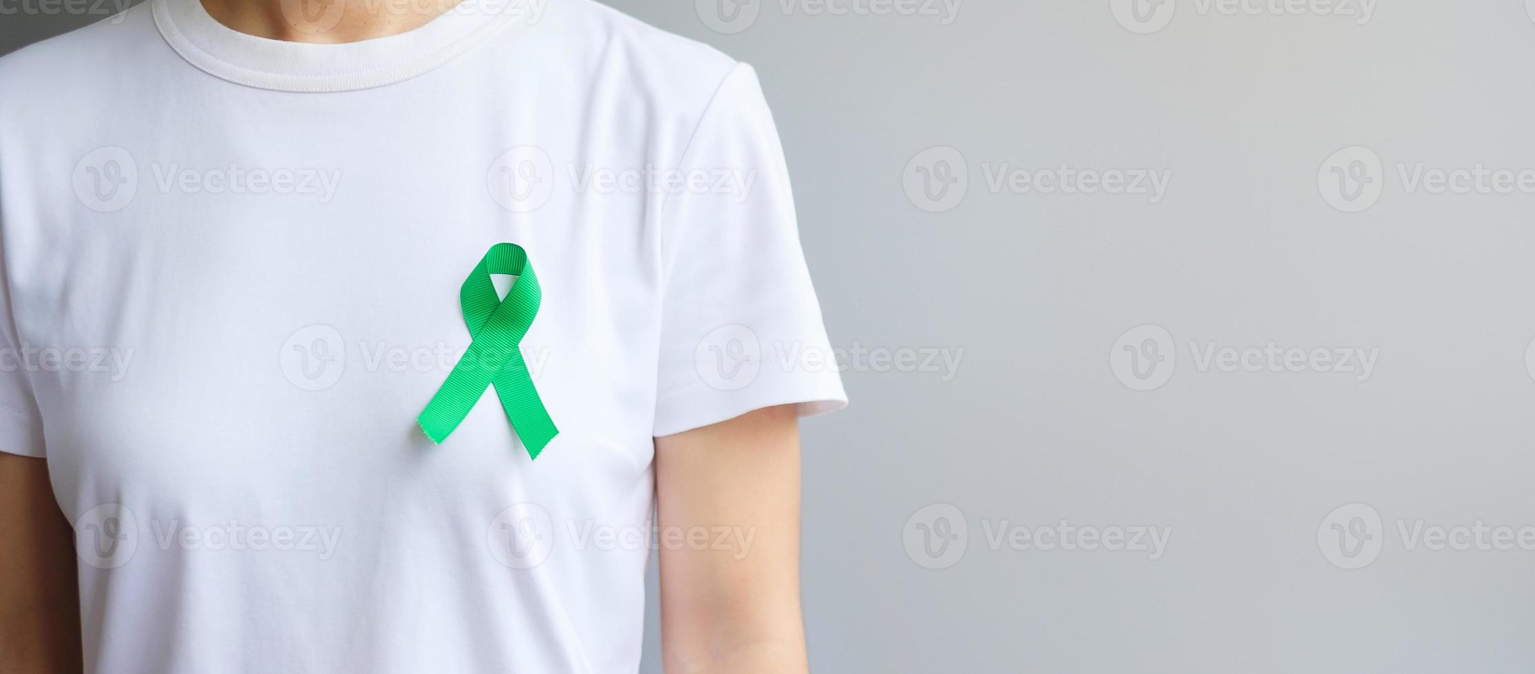 cinta verde para el mes de concientización sobre el hígado, las vesículas biliares, las vías biliares, el cuello uterino, el cáncer de riñón y el linfoma. concepto de salud y día mundial del cáncer foto