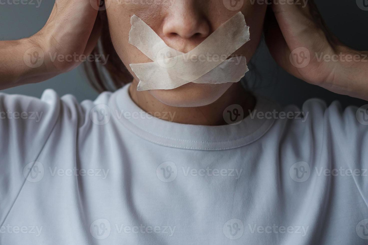 woman with mouth sealed in adhesive tape. Free of speech, freedom of press, Human rights, Protest dictatorship, democracy, liberty, equality and fraternity concepts photo