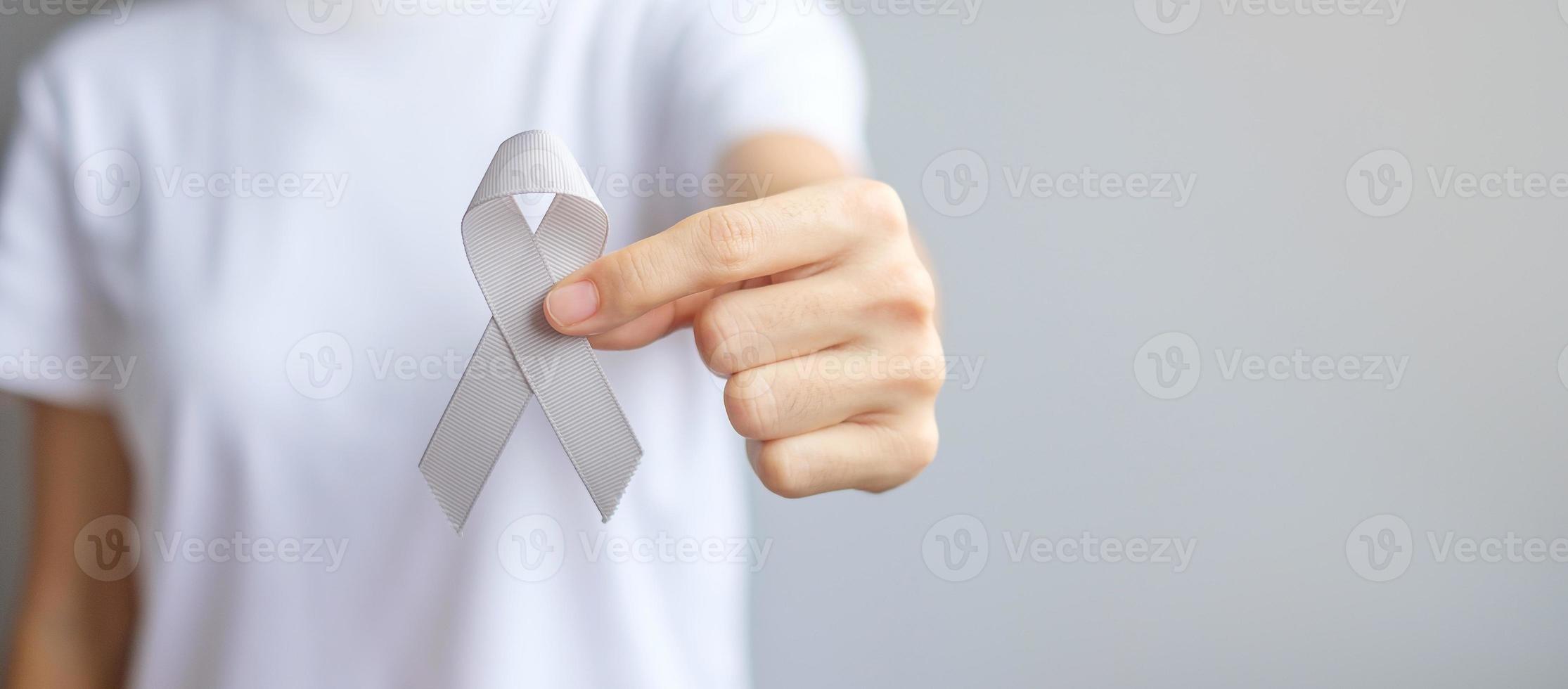 Brain Cancer Awareness month, woman hand holding grey color Ribbon for supporting people living. Healthcare and World cancer day concept photo