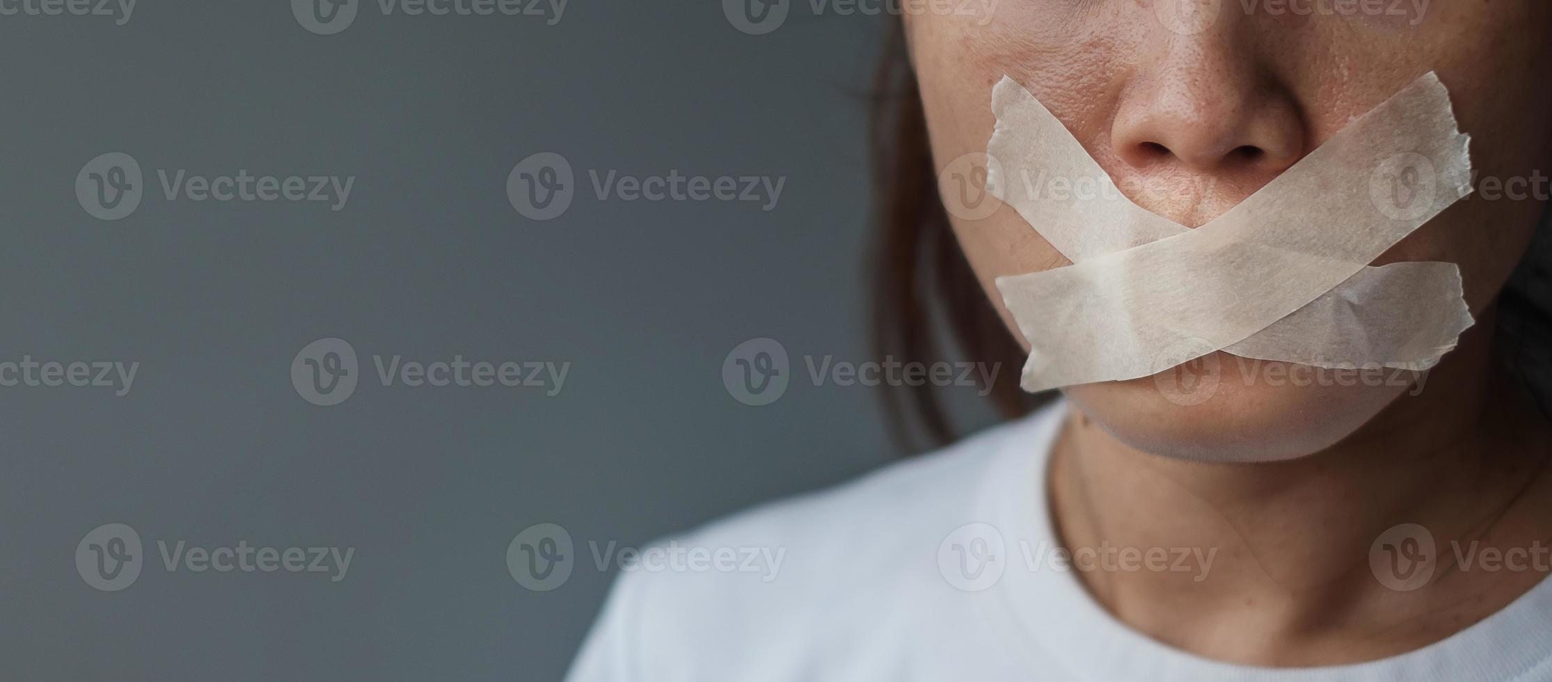 woman with mouth sealed in adhesive tape. Free of speech, freedom of press, Human rights, Protest dictatorship, democracy, liberty, equality and fraternity concepts photo