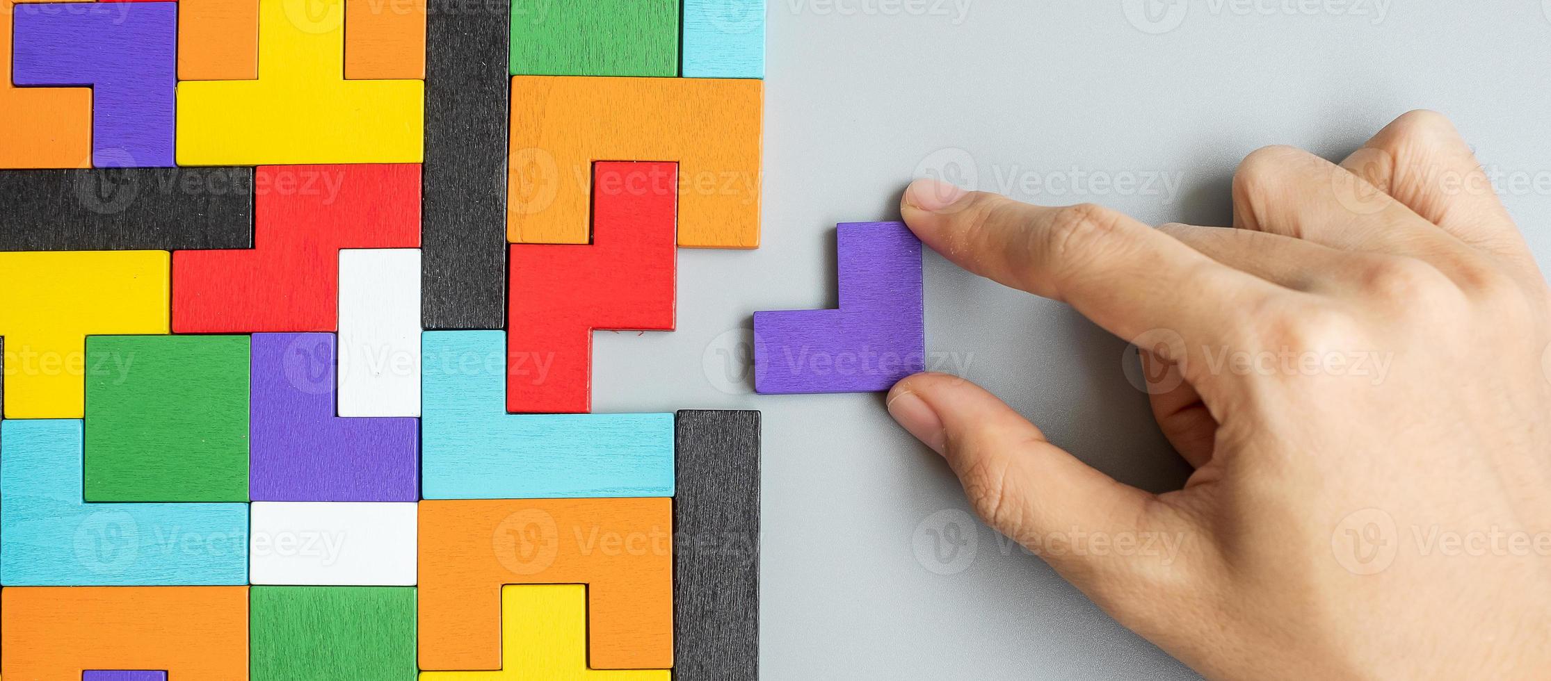 hand connecting geometric shape block with colorful wood puzzle pieces. logical thinking, business logic, Conundrum, decision, solutions, rational, mission, success, goals and strategy concepts photo