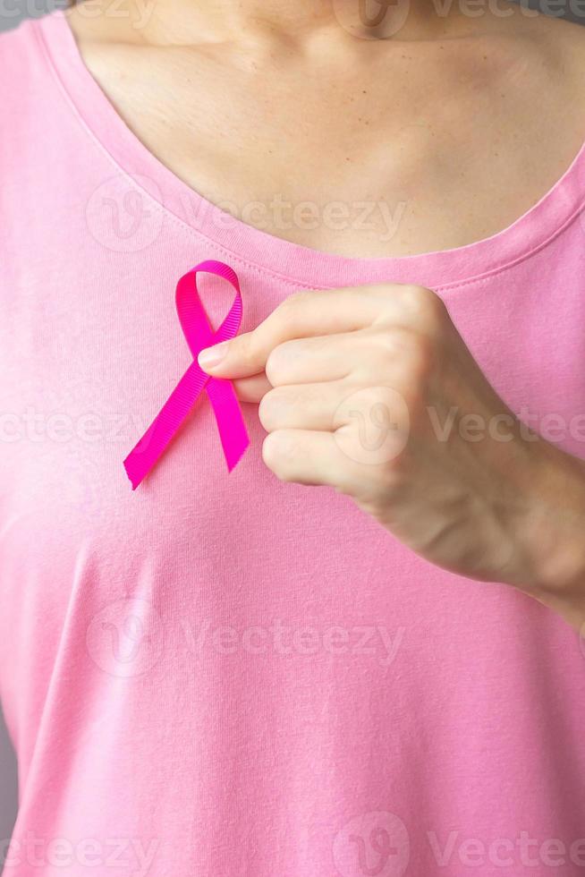 October Breast Cancer Awareness month, elderly Woman in pink T- shirt with hand holding Pink Ribbon for supporting people living and illness. International Women, Mother and World cancer day concept photo