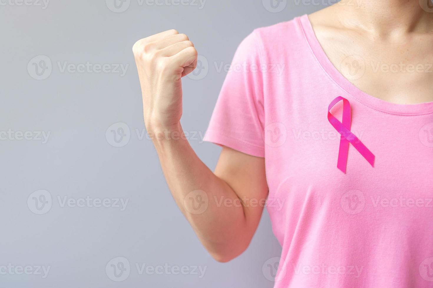 October Breast Cancer Awareness month, elderly Woman in pink T- shirt with Pink Ribbon and fist sign for supporting people living and illness. International Women, Mother and World cancer day concept photo