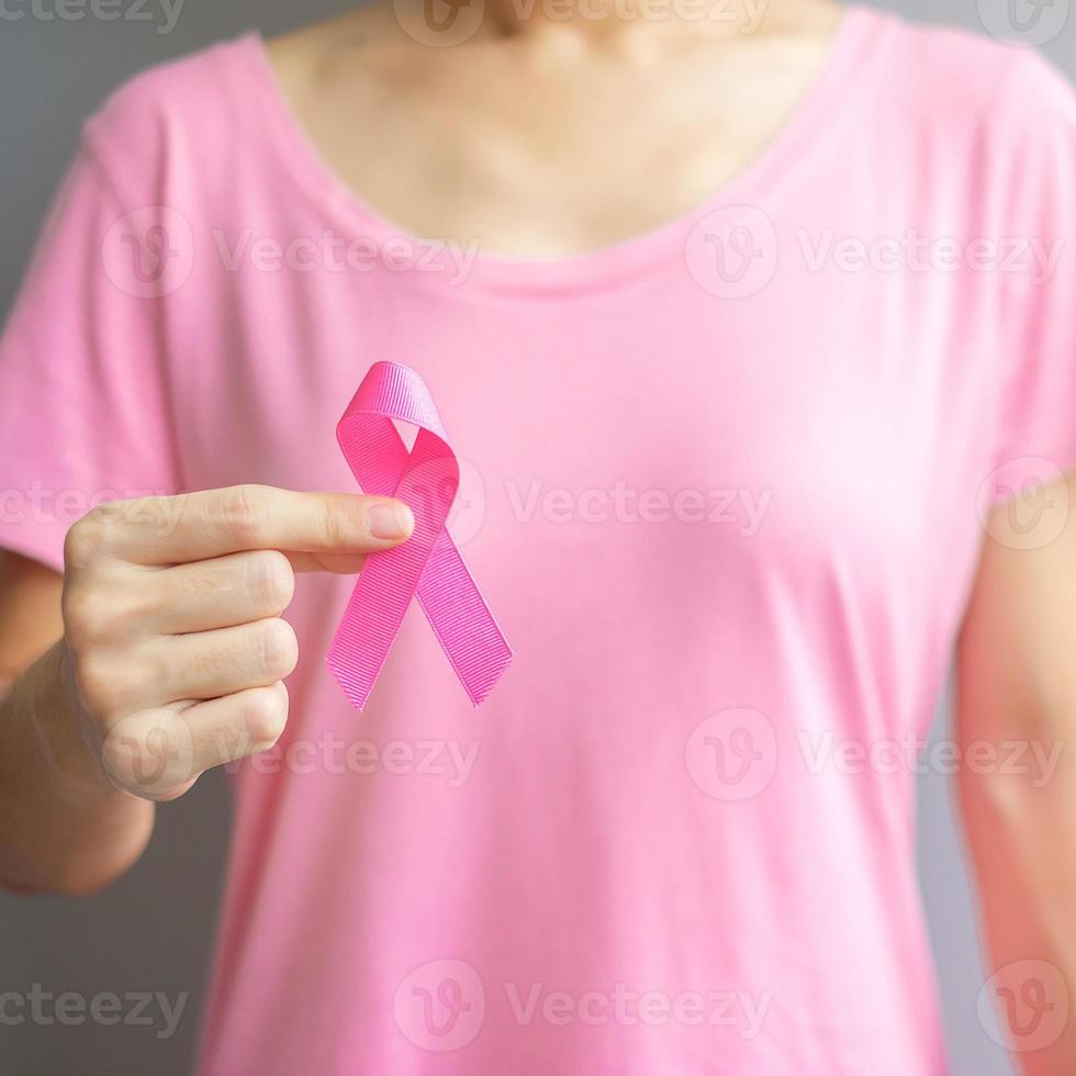 octubre mes de concientización sobre el cáncer de mama, anciana con camiseta rosa con la mano sosteniendo una cinta rosa para apoyar a las personas que viven y están enfermas. concepto del día internacional de la mujer, la madre y el día mundial del cáncer foto