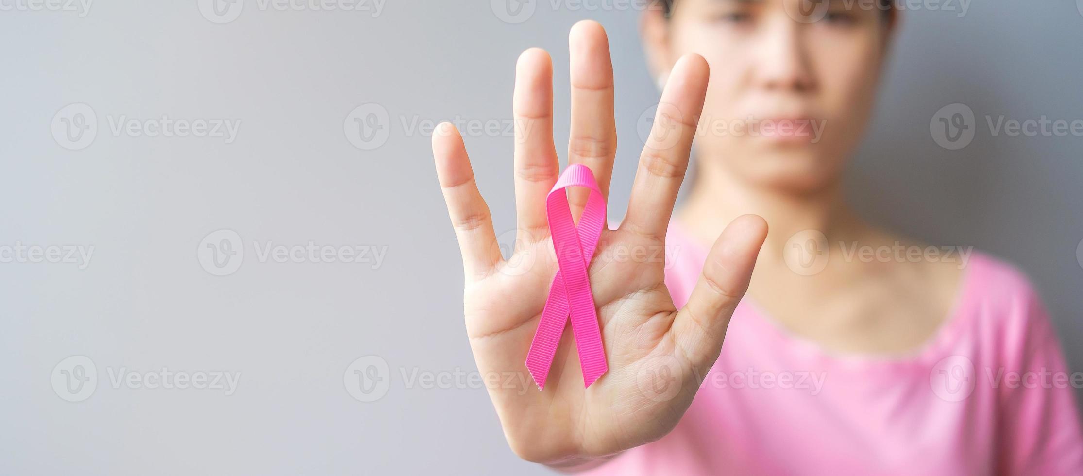 October Breast Cancer Awareness month, elderly Woman in pink T- shirt with hand holding Pink Ribbon for supporting people living and illness. International Women, Mother and World cancer day concept photo