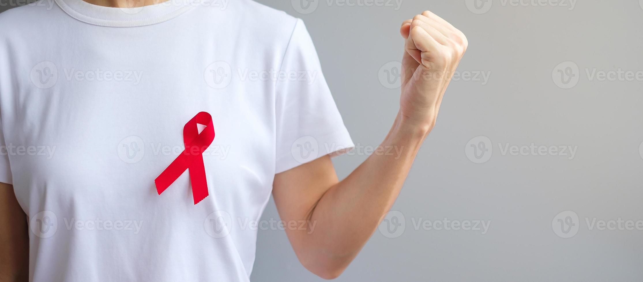 Hand holding Red Ribbon for December World Aids Day , multiple myeloma Cancer Awareness month and National Red ribbon week. Healthcare and world cancer day concept photo