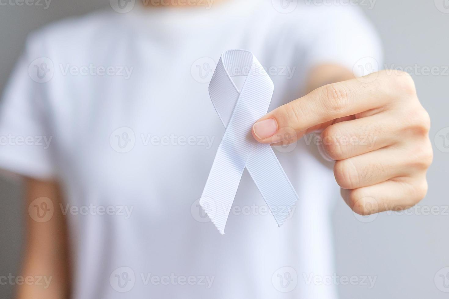 Woman holding white Ribbon for November Lung Cancer Awareness month, democracy and international peace day. Healthcare concept photo