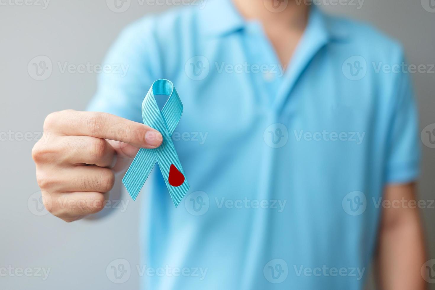 November World Diabetes day Awareness month, man holding light Blue Ribbon with blood drop shape for supporting people living, prevention and illness. Healthcare, prostate cancer day concept photo
