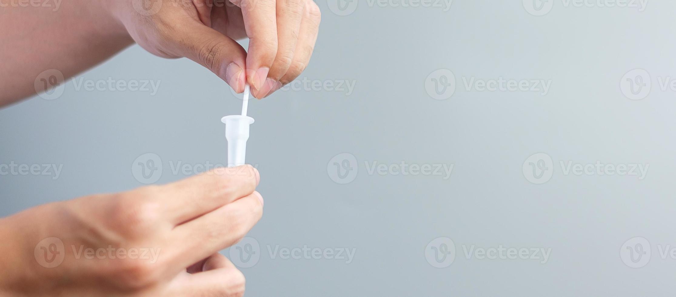 man swab COVID-19 testing by Rapid Antigen Test kit. Coronavirus Self nasal or Home test, Lockdown and Home Isolation concept photo