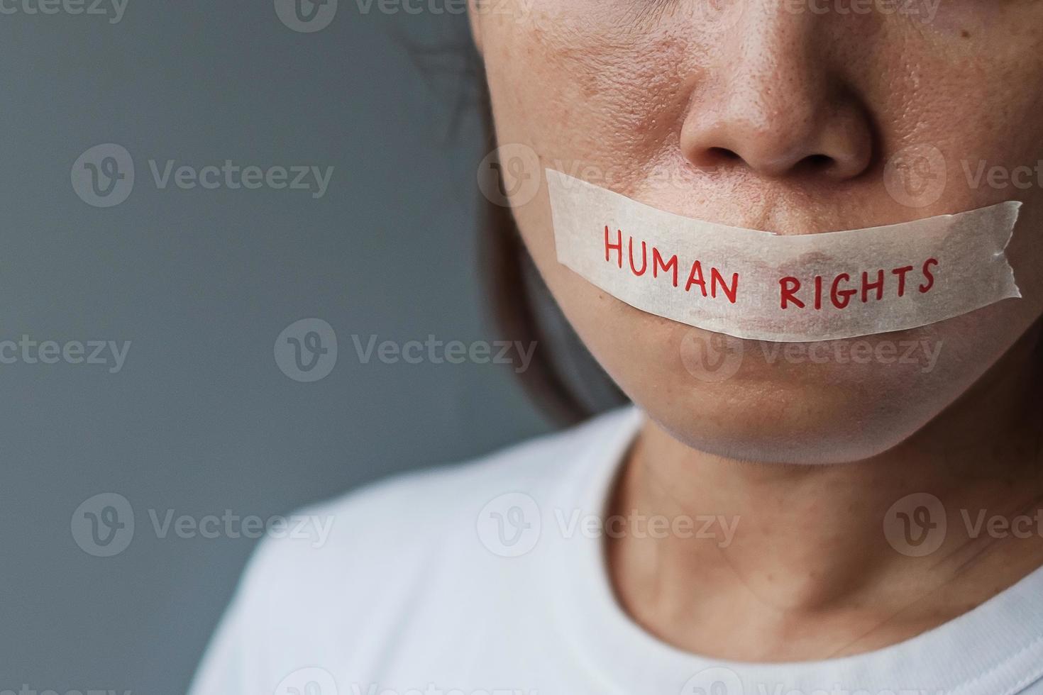 woman with mouth sealed in adhesive tape with Human rights message. Free of speech, freedom of press, Protest dictatorship, democracy, liberty, equality and fraternity concepts photo
