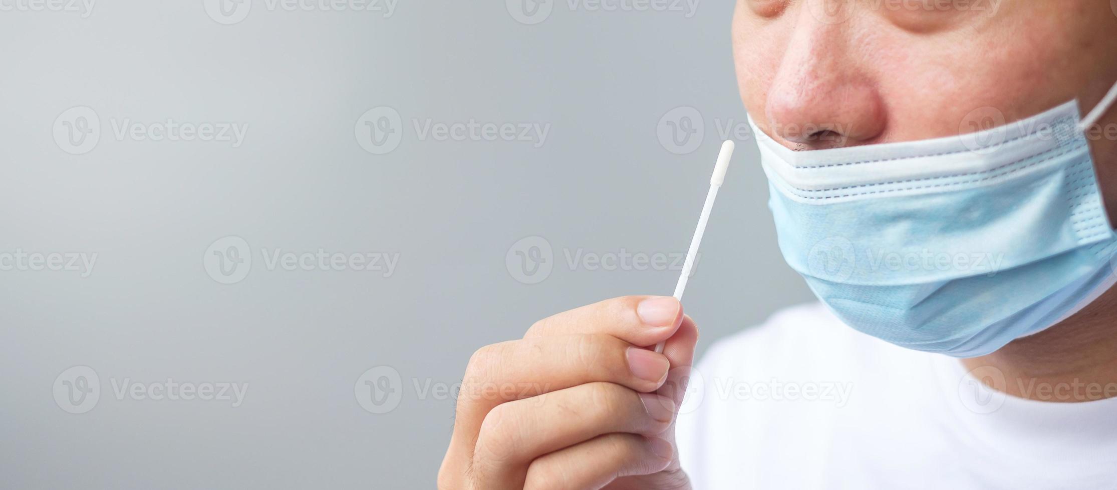 man swab COVID-19 testing by Rapid Antigen Test kit. Coronavirus Self nasal or Home test, Lockdown and Home Isolation concept photo