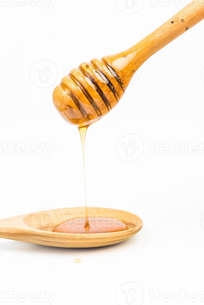 wooden honey dipper on white background photo