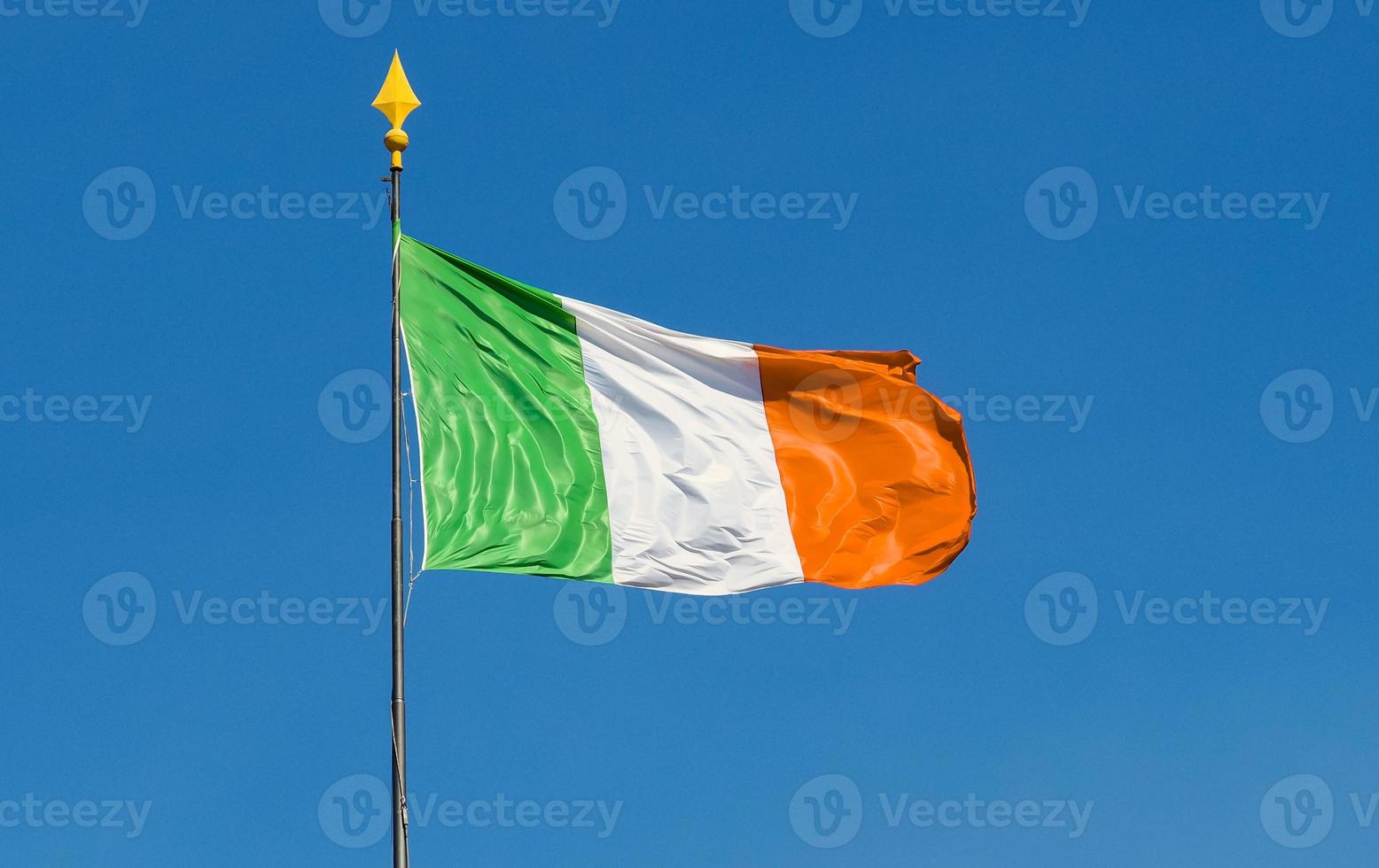 Bandera de Irlanda ondeando en el cielo azul foto