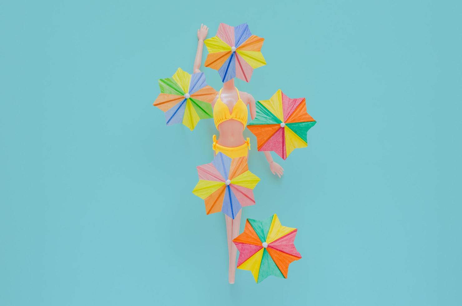 A doll wearing yellow swimming suit with cocktail umbrellas photo