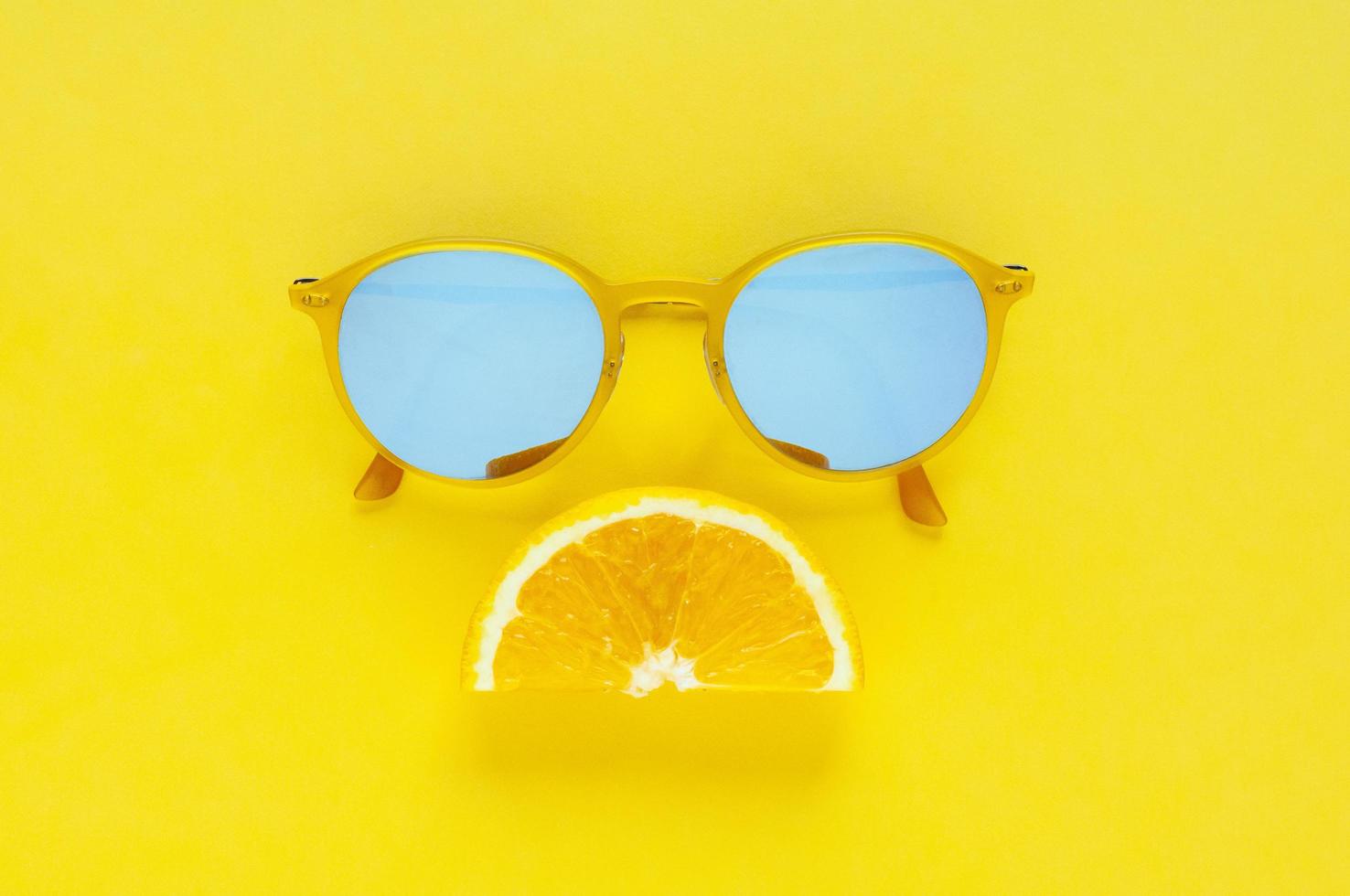 Slice orange fruit set as sad mouth and yellow sunglasses. photo