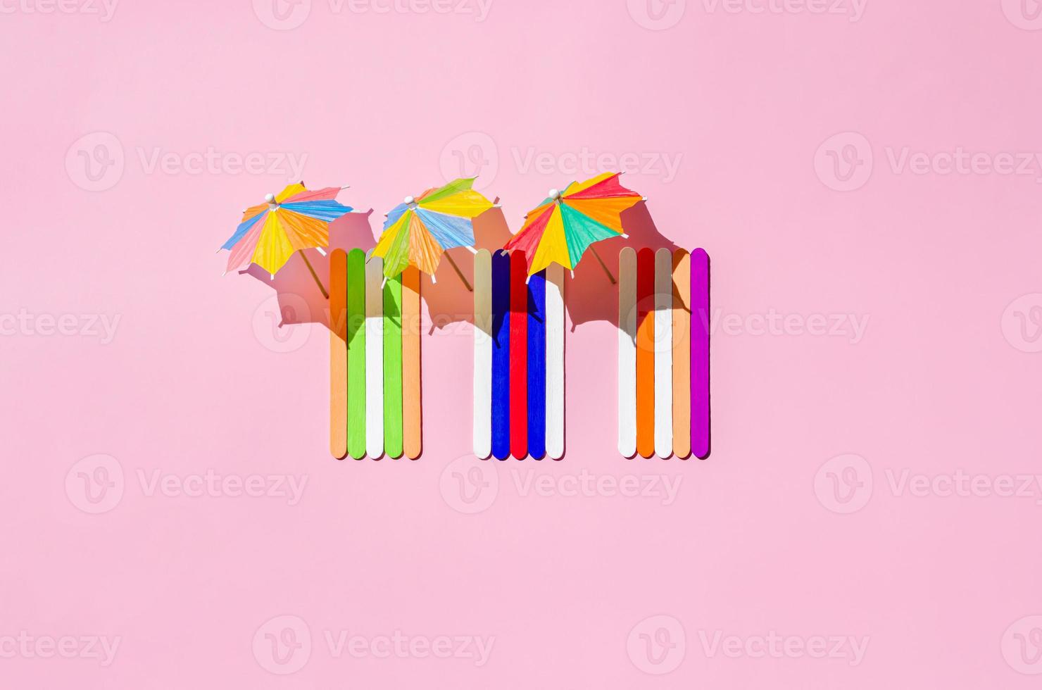 Colorful beach towels with sun umbrellas on pink sand beach. photo